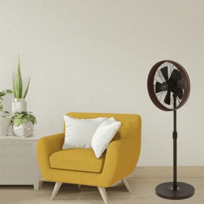 Ventilateur sur pied à côté d'un fauteuil jaune (Disponible sur France-Ventilateur)