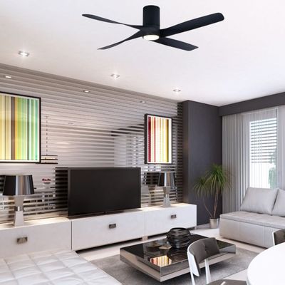 Ventilateur plafond design noir suspendu au centre d’un salon moderne avec canapé gris et meuble TV blanc